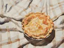 Schilderij van een appeltaart op een geruit tafelkleed