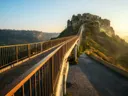 Voetgangersbrug naar het op een rotsplateau gelegen stadje Civita di Bagnoregio bij zonsopkomst