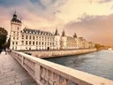 De Conciergerie in Parijs gezien over de Seine bij zonsondergang