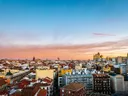 Stadspanorama met rode pannendaken bij zonsondergang