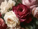 Schilderij van een donkerrode roos tussen tuinbloemen