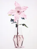 Een roze bloem in een klein glazen vaasje.