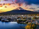 Berg Fuji boven een Japans stadje aan een meer bij zonsondergang
