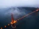 Luchtfoto van de verlichte Golden Gate Bridge omhuld door mist.