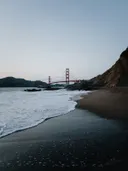 Uitzicht op de Golden Gate Bridge vanaf een strand met golvend water op de voorgrond
