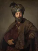 Halffiguur van een man in oosterse kleding van Rembrandt and workshop: portret met man, tulband, baard en mantel, in donkerbruin en rood