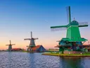 Traditionele Nederlandse windmolens aan het water bij zonsondergang.