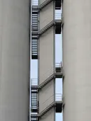 Metalen zigzagtrap tussen twee grote betonnen silo's