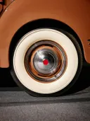 Close-up van een witwandband en chromen wieldop op een vintage auto