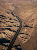 Luchtfoto van een kronkelende snelweg door een geërodeerd woestijnlandschap