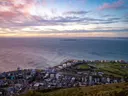 Luchtfoto van een kuststad aan zee bij zonsondergang.