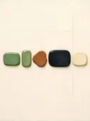 Losse kiezelstenen in de stijl Organic Geometry, in saliegroen, romige crème en terracotta, met een diepzwart accent