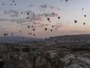 Luchtballonnen boven het rotsachtige landschap van Cappadocië bij zonsopkomst.