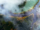 Luchtfoto van een rivier tussen herfstbossen met laaghangende mist