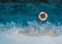Luchtfoto van zee en strand met een oranje zwemband