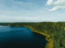 Luchtfoto van een blauw meer omringd door bos met herfstkleuren