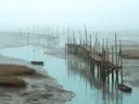 Schilderij van een mistige vissteiger in het wad