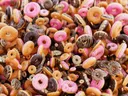 Close-up van een grote hoeveelheid donuts met roze en chocoladeglazuur.