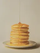 Schilderij van een stapel pannenkoeken met stroop