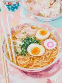 Schilderij van een kom ramen met eieren, noedels en lente-ui, met eetstokjes ernaast.