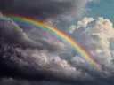 Regenboog door stormwolken, landschap schilderij