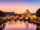 Verlichte brug over de Tiber met de Sint-Pietersbasiliek op de achtergrond in Rome