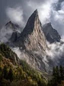 Schilderij van een rotsspits die door de wolken breekt