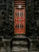 Versierde tempeldeur met stenen wachtersbeelden op Bali