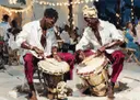 Schilderij van twee mannen die djembe trommels spelen tijdens een nachtfeest
