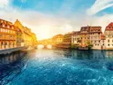 Historische vakwerkhuizen langs een kanaal in Straatsburg bij zonsondergang.