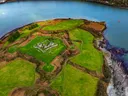 Luchtfoto van een vervallen fort op een groen schiereiland omgeven door water.