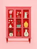Roze vitrinekastje met rood interieur vol kleurrijke vazen, kruiken en bloemen.
