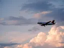 Vliegtuig vliegend tussen wolken bij zonsondergang.