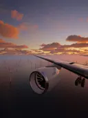 Zicht op een vliegtuigvleugel en motor boven een windmolenpark op zee bij zonsondergang.