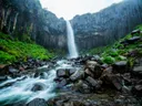 Waterval die neerstort tussen zwarte basaltzuilen in IJsland.