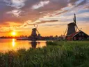 Windmolens aan het water tijdens een vurige zonsondergang