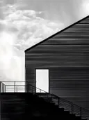 Zwart gebouw met trap tegen wolkenlucht