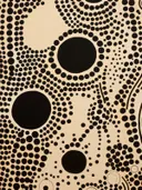 Abstracte stippenpatroon compositie met zwarte cirkels op crèmekleurige ondergrond