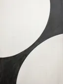 Minimalistisch abstract werk met een grote zwarte gebogen vorm op witte achtergrond.