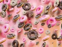 Donuts met roze en chocoladeglazuur die door de lucht zweven.