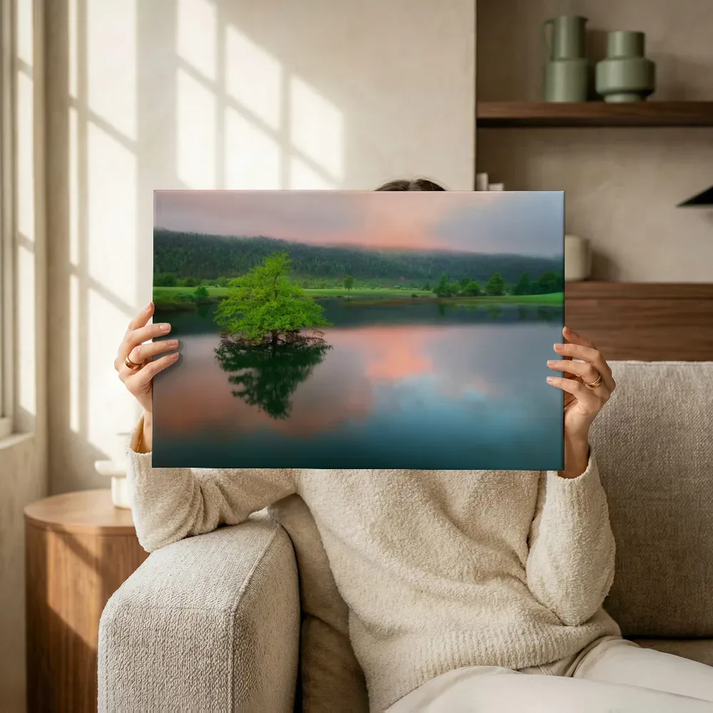 Sfeerimpressie: Eenzame boom in spiegelend meer bij zonsondergang terwijl het omhoog wordt gehouden