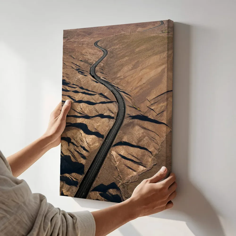 Sfeerimpressie: Kronkelende woestijnweg vanuit de lucht terwijl het aan de muur wordt gehangen