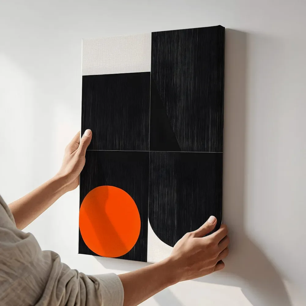 Sfeerimpressie: Minimalistische zwarte vormen met oranje terwijl het aan de muur wordt gehangen