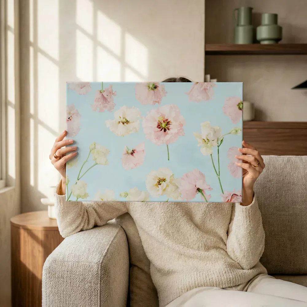 Sfeerimpressie: Pastelroze bloemen op zachtblauw terwijl het omhoog wordt gehouden