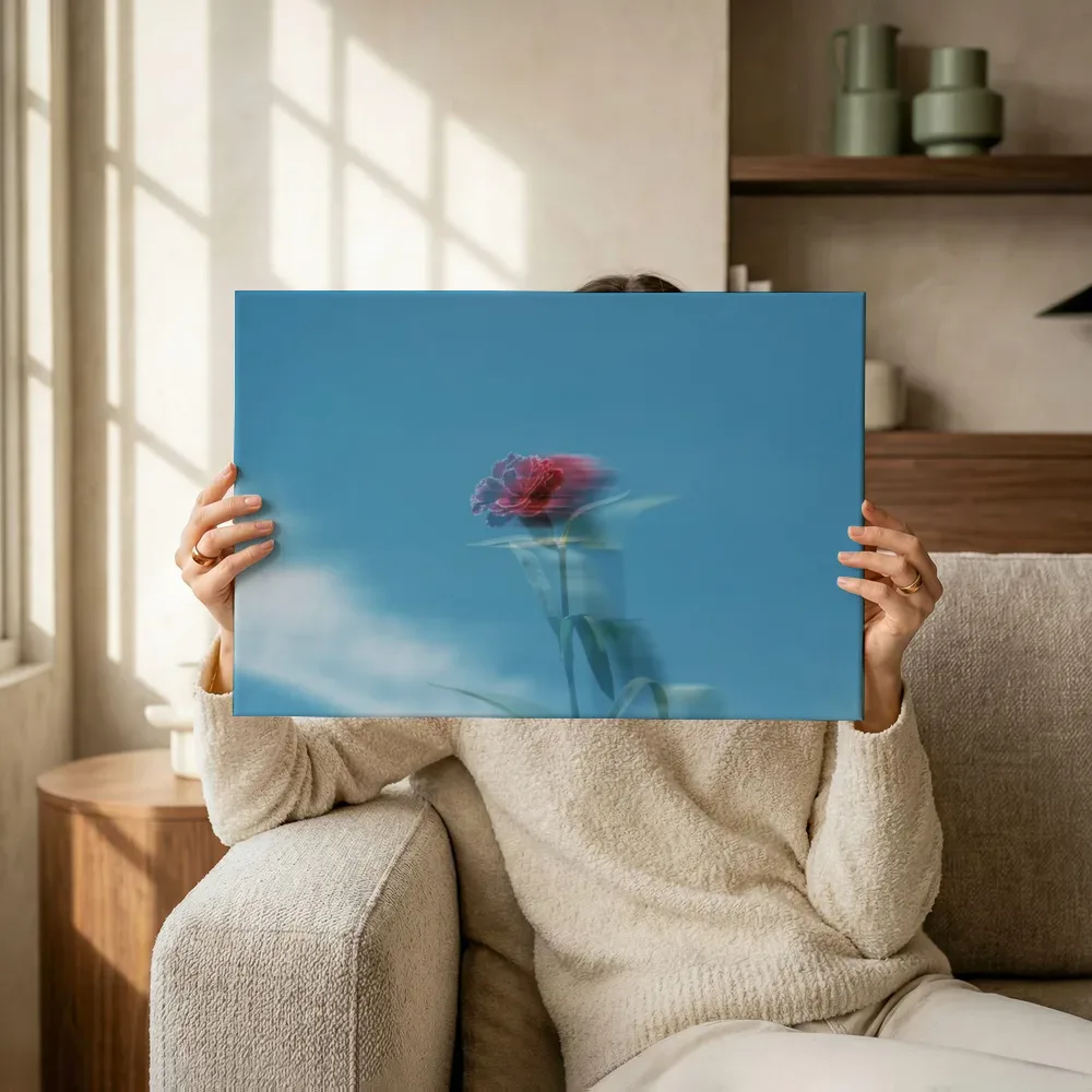 Sfeerimpressie: Rode bloem tegen blauwe lucht terwijl het omhoog wordt gehouden