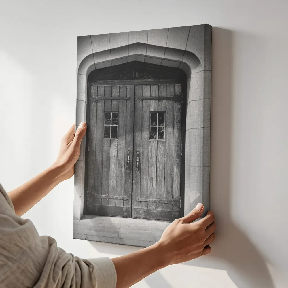 Sfeerimpressie: Statige houten poortdeur in zwart-wit terwijl het aan de muur wordt gehangen