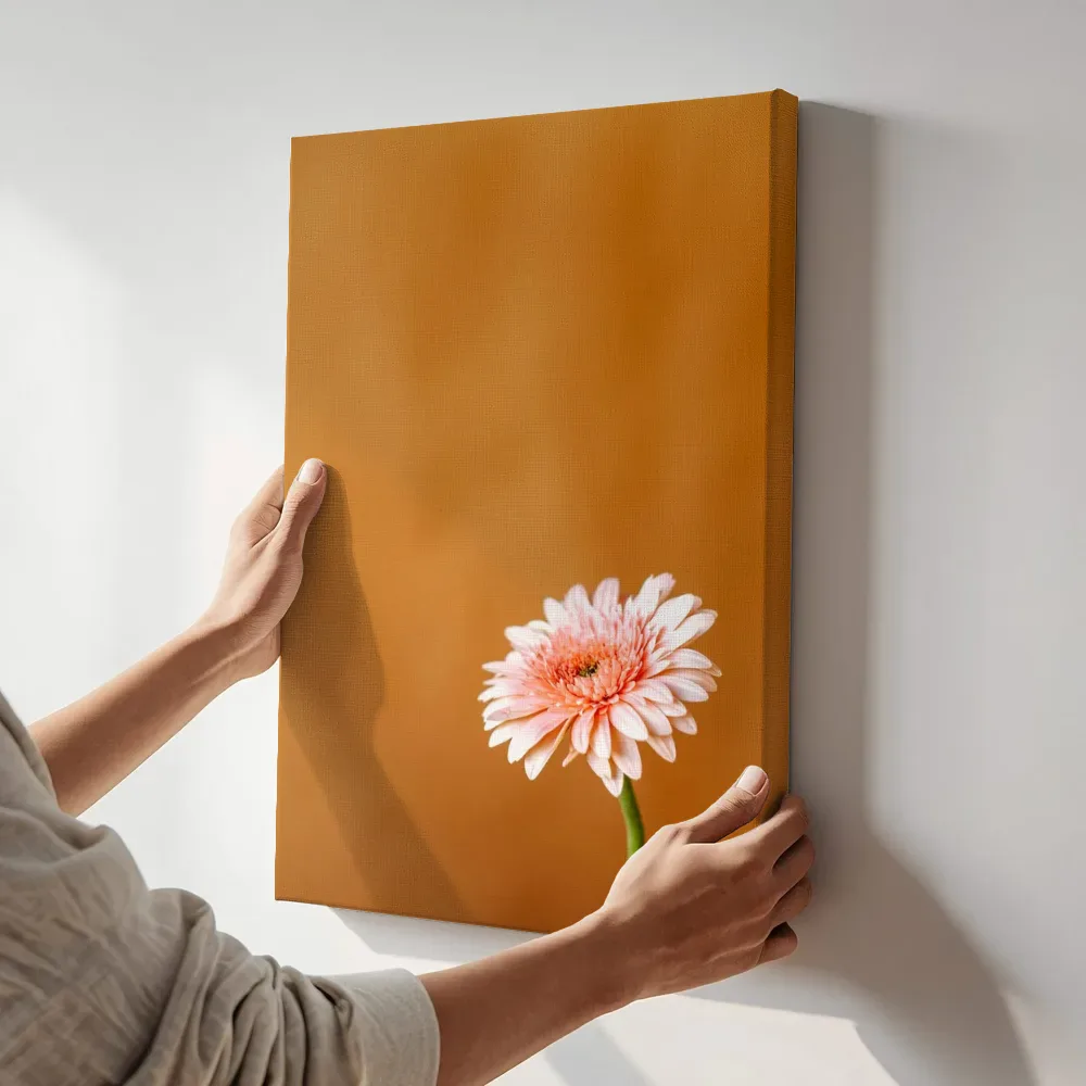 Sfeerimpressie: Zachtroze gerbera op oker terwijl het aan de muur wordt gehangen